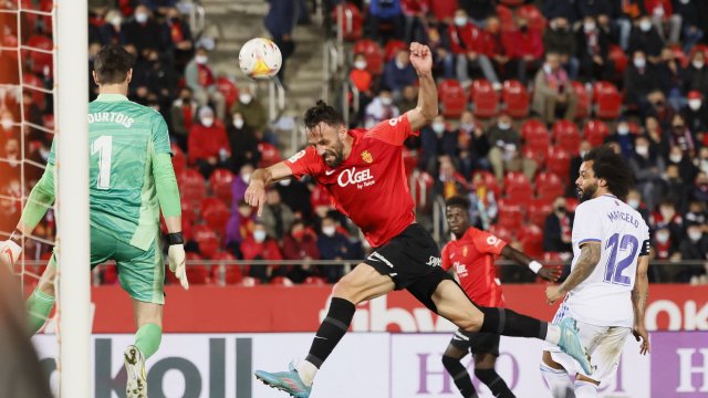 Vedat Muriqi rematando un balón ante Thibaut Courtois