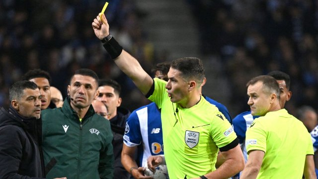 L'arbitre Istvan Kovacs donne un carton jaune en Champions League