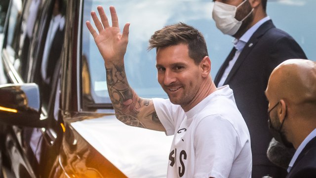 Lionel Messi salue les supporters en sortant du taxi, devant le Royal Monceau à Paris.